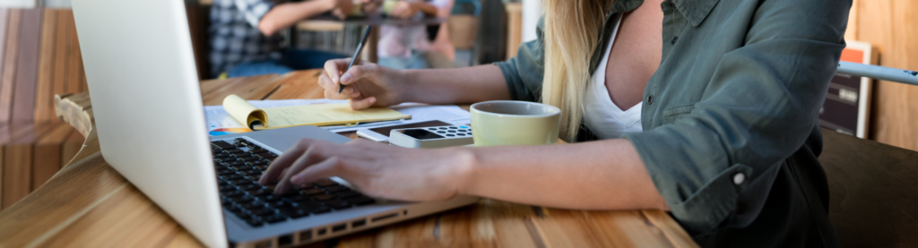 Woman working on laptop at restaurant table