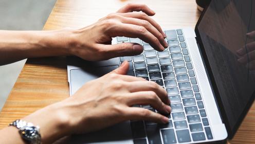 Hands working on laptop
