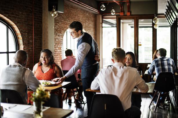 Restaurant server delivering food to table