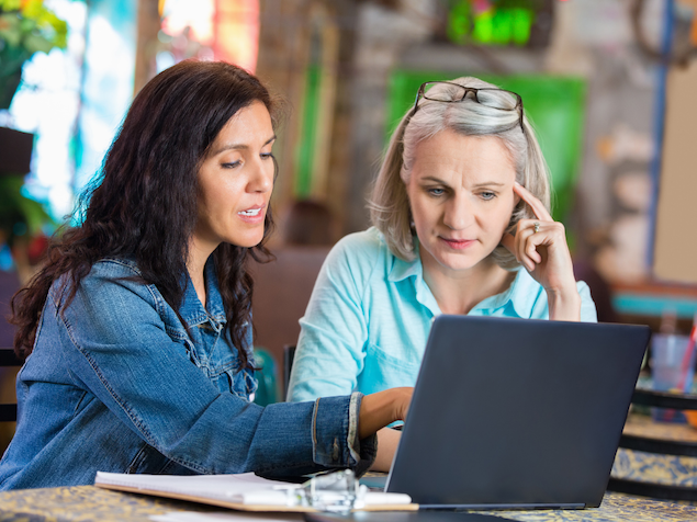 2 Women looking at laptop in restaurant