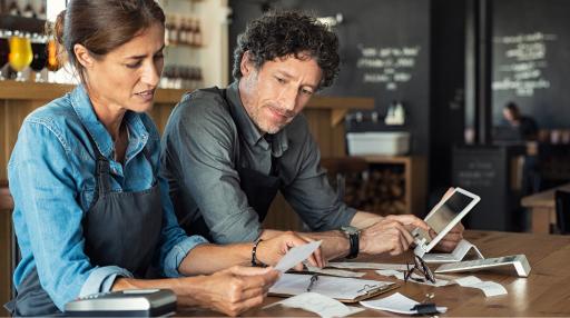 Couple reviewing restaurant accounting data at table