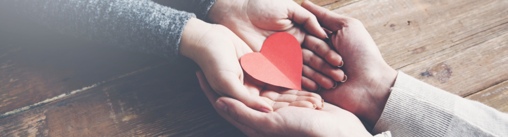Hands holding paper heart cutout