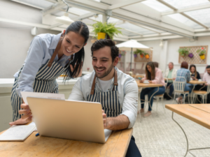 Restaurant operators reviewing financial statements on laptop