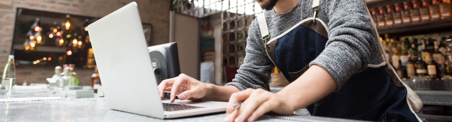 Restaurant operator looking at computer in restaurant
