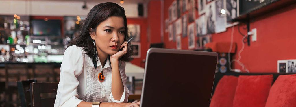 Woman looking at laptop in restaurant.