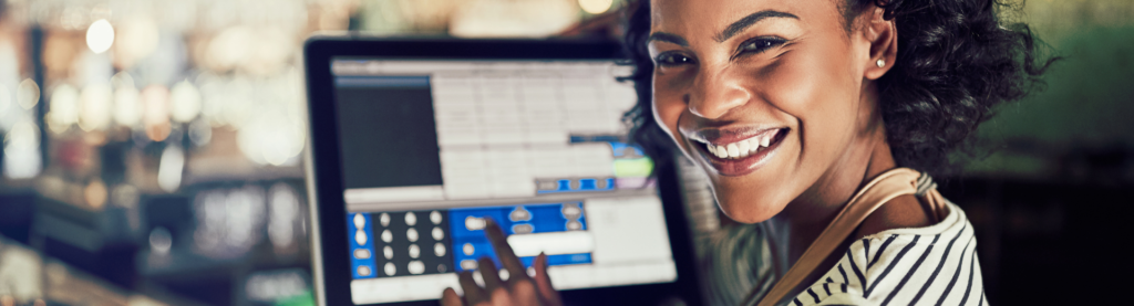 Woman smiling at camera with POS system in background