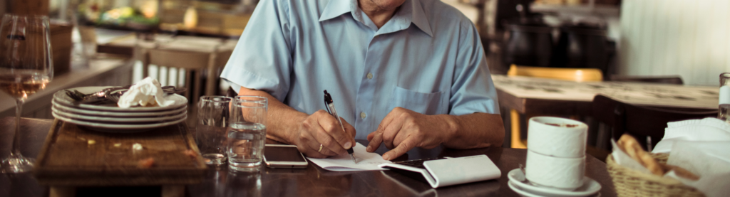Restaurant owner working on bookkeeping in the dining room.